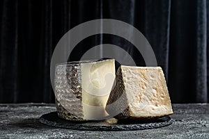 Spanish manchego cheese sliced on dark background. traditional spanish cheese