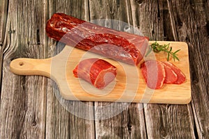 Spanish meat delicacy from pork dry-cured carbonade Lomo Curado on wooden board. Iberian pork slices