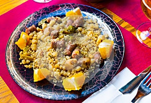 Spanish Migas tropezones from fried flour with bacon, sausage, peppers and orange