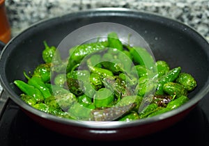Spanish national food - fried green Padron peppers photo