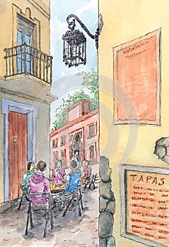 Spanish old street with seated persons