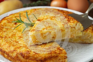 Spanish omelette with potatoes and onion, typical Spanish cuisine. Tortilla espanola. Rustic dark background