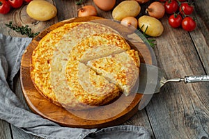 Spanish omelette with potatoes and onion, typical Spanish cuisine. Tortilla espanola. Rustic dark background. Top view