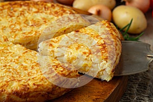 Spanish omelette with potatoes and onion, typical Spanish cuisine. Tortilla espanola. Rustic dark background. Top view