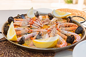 Spanish paella rice served on the pan under the sun