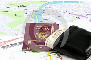 Spanish passport with european union currency in a wallet and map