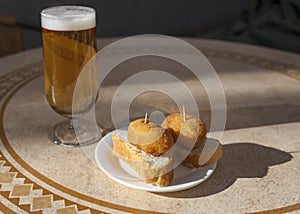 Spanish pincho of croquettes close to glass of beer