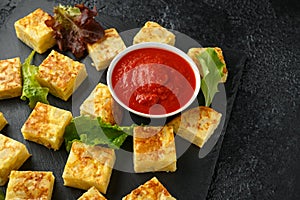 Spanish Potato Frittata tapas with tomato sauce on stone board