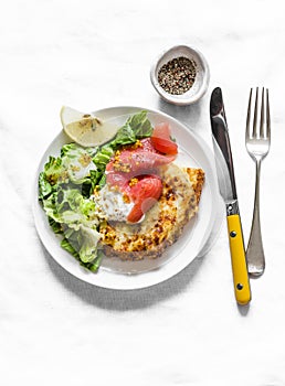 Spanish potato tortilla with greek yogurt, smoked salmon and green salad on a light background, top view. Delicious breakfast,