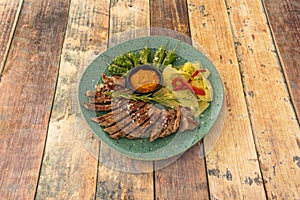 Spanish recipe of Iberian pork feather dish with baked potatoes, roasted peppers and fried padrÃ³n peppers