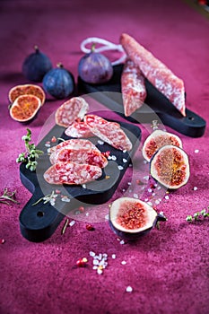 Spanish salami fuet with fresh figs - dry-cured and natural fermented sausages