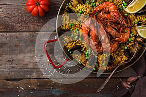 Spanish Seafood Paella Rice Dish with Fresh Shellfish Served with Lemon Wedges in Pan, copy space
