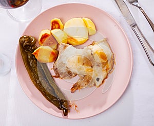 Spanish Secreto de cerdo - roasted pork served with potatoes, stewed pepper photo