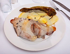 Spanish Secreto de cerdo - roasted pork served with potatoes, stewed pepper photo