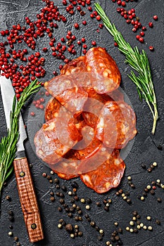 Spanish sliced chorizo sausage. cured meat. Black background. Top view