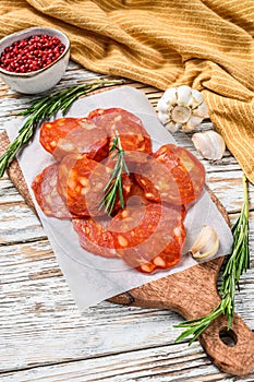 Spanish sliced chorizo sausage on a cutting board. cured meat. White background. Top view