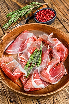 Spanish sliced Jamon Serrano pork ham. wooden background. Top view