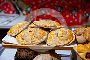 Spanish snacks and street food, baked pie empanadilla with different filling on market in San-Sebastian, Spain