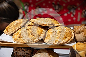 Spanish snacks and street food, baked pie empanadilla with different filling on market in San-Sebastian, Spain