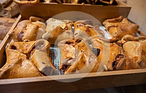 Spanish snacks and street food, baked pie empanadilla with different filling on market in San-Sebastian, Spain