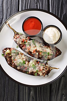 Spanish Stuffed Eggplant Recipe Berenjenas Rellenas close-up in a plate. Vertical top view photo