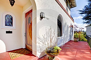 Spanish style white house with red porch