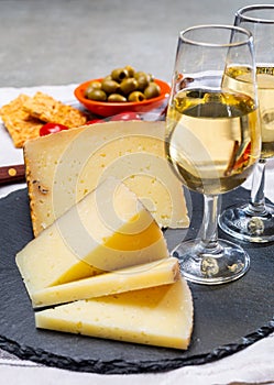 Spanish tapas, manchego cheese made, green olives served with glasses of dry fino sherry wine