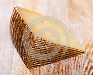 Spanish tasty sheep cheese Manchego on wooden surface