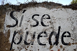 Spanish text painted on a wall: si se puede photo