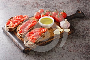 Spanish tomato toast pan tomaca or tostadas con tomate closeup on the wooden board. Horizontal photo