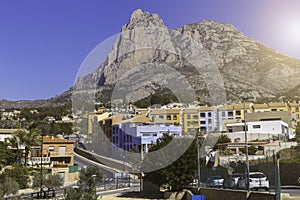 Spanish village with colorful houses at the foot of the Puig Campana rocks. photo