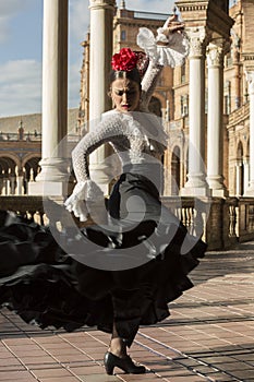 Spanish woman dancing flamenco dance in a beautiful monumental place