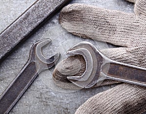 Spanners and gloves on a metal background