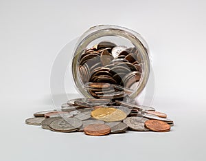 Spare change spilling out of coin savings jar