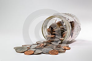 Spare change spilling out of coin savings jar