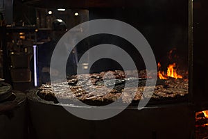 Spare ribs cooking on barbecue grill. Grill restaurant open kitchen. Chef cooking ribs in BBQ