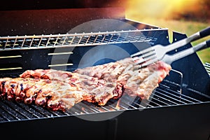 Spare ribs cooking on barbecue grill for summer outdoor party. F