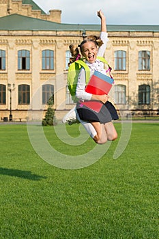 Spare time. Energetic kid jump in schoolyard. School holidays. Happy pupil in midair. Graduation day. Primary education