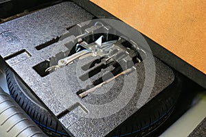 Spare tire in good condition and tools in the trunk of modern car, ready to use.