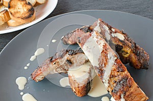 Spareribs on grill with dip and toasted baguette