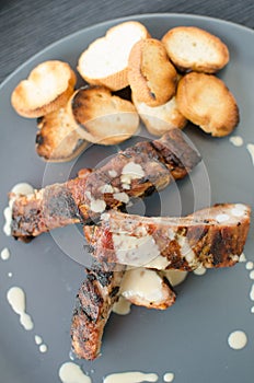 Spareribs on grill with dip and toasted baguette