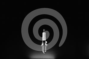 Spark plug isolated on black background. Spare part for a vehicle with an internal combustion engine, gasoline. A new detail. Car