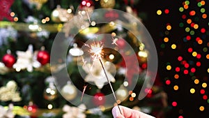 Sparkle fire burning in front of Christmas tree with blinking lights