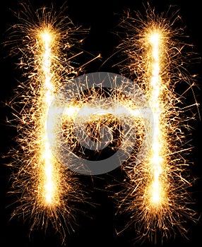 Sparkler firework light alphabet H on black