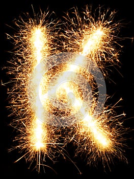 Sparkler firework light alphabet K on black