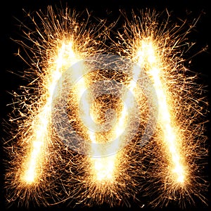 Sparkler firework light alphabet M on black