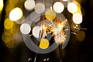 Sparklers with bokeh spot lights with copy space on black background