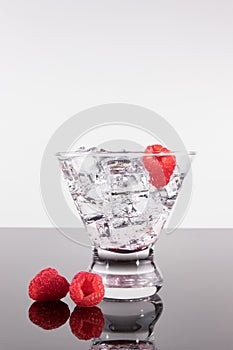 Sparkling beverage in a martini glass with raspberries