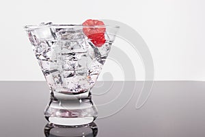 Sparkling beverage in a martini glass with raspberry