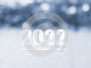Sparkling blue and white tone bokeh with text Happy New Year 2022 for the holiday background.